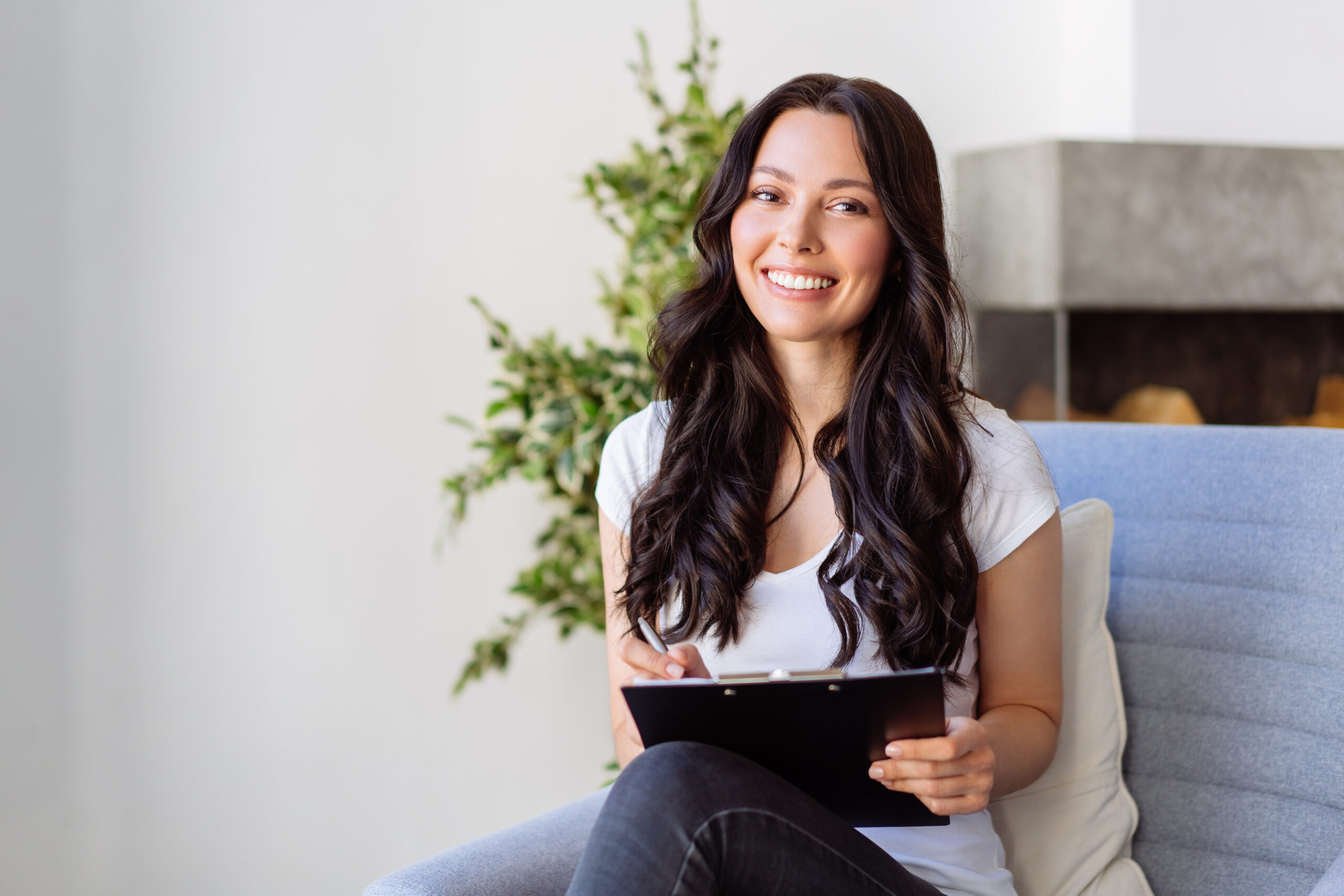 Portrait of a young woman in the office. Woman writes data to the questionnaire.